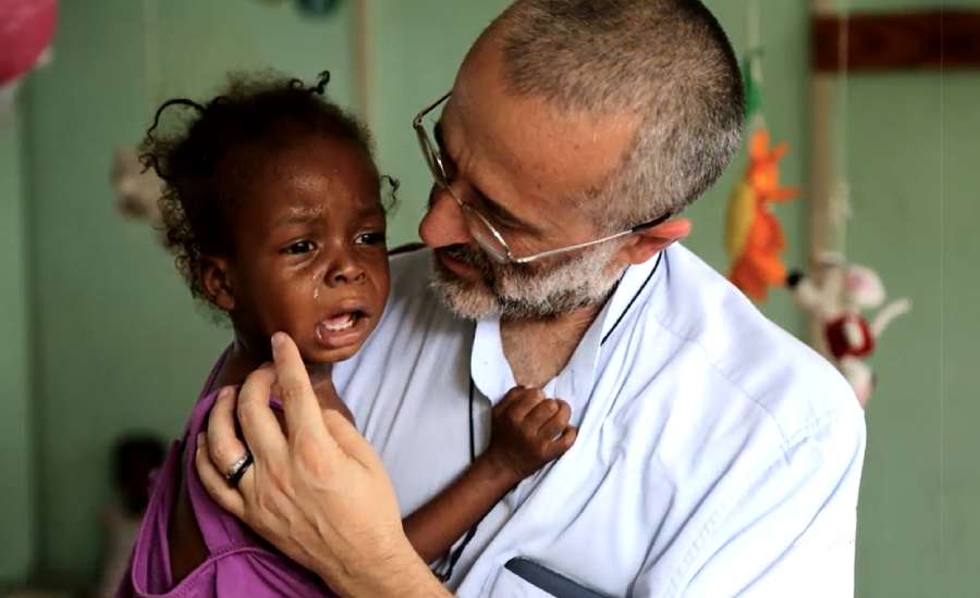 Padre Gianpietro Carraro com uma das crianças atendidas. Foto: Captura de vídeo / Missão Belém